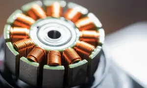 Szczegółowy widok uzwojeń silnika elektrycznego, który zamienia energię. Miedziane druty nawinięte na rdzeń.