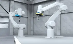 Dwa białe ramiona robotyczne w hali produkcyjnej, jedno z chwytakiem, drugie z przyssawką, gotowe do sterowania robotem.