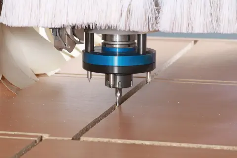 Głowica frezująca CNC precyzyjnie wycina linie na płycie, optymalizując materiał dzięki technice cnc nesting.